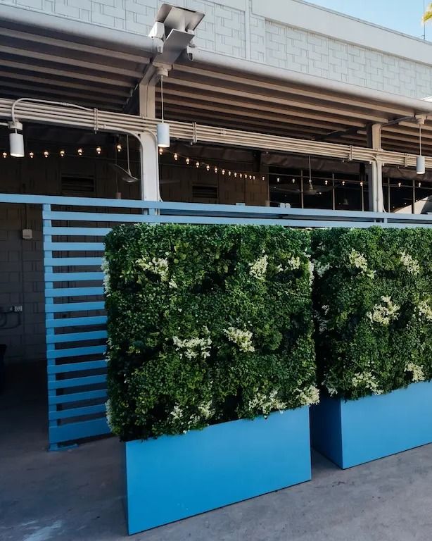 Freestanding artificial privacy wall units in planter bases screening a patio